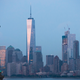 The Statue of Liberty stands in the foreground as Lower Manhattan is viewed at dusk.